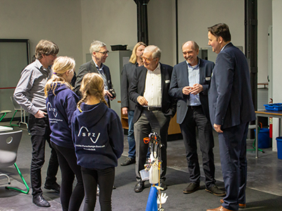 Schülerinnen zeigen den Gästen bei der Eröffnung in Bad Laer ihren Spenden-Roboter.